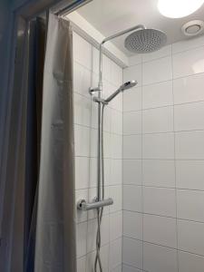een douche in een badkamer met een douchegordijn bij Studio aan het strand in Zoutelande