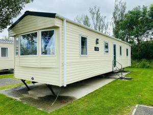 a small white trailer parked in a yard at 5 mins walk to beach. 3 bedroom caravan. Sleeps 8 in Clacton-on-Sea