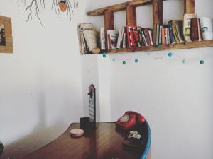 een bureau met een rode telefoon en boeken op een plank bij Turismo Rural casa da céu in Amiães de Cima