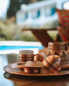 a plate with bowls and cups on a table at Lemon Garden Türkbükü in Türkbükü