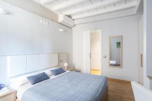 a white bedroom with a large bed with blue pillows at Spanish Steps House Vittoria in Rome