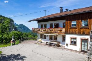 ein Haus mit einem Balkon mit Blumen darauf in der Unterkunft Ferienwohnung Brunnerlehen in Berchtesgaden