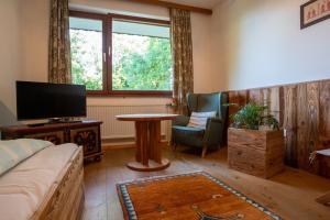 ein Wohnzimmer mit einem Sofa, einem TV und einem Tisch in der Unterkunft Haus Kogler in Inzersdorf im Kremstal