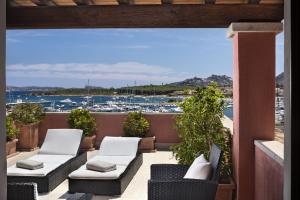 a balcony with chairs and a view of a harbor at La Vecchia Fonte Boutique Hotel in Palau