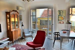 ニースにあるLes Gérardines, 3-room with Airco and balconyのリビングルーム(赤い椅子、テーブル付)