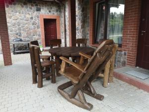 drewniany stół i krzesła na patio w obiekcie Brzozowy Zaułek w mieście Bydlino