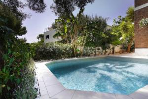 a swimming pool in front of a house at Luxury House with Pool in Castelldefels