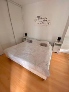 a bed in a room with a wooden floor at Charmant appartement en bord de Cher in Saint-Avertin