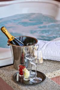 a tray with wine glasses and a bucket with a bottle at La Vecchia Fonte Boutique Hotel in Palau