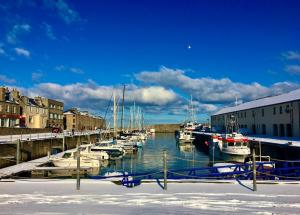 een groep boten aangemeerd in een haven bij Beachfront Panoramic Seaview Free Wifi & Parking in Lossiemouth