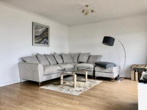 a living room with a couch and a table at Beachfront Panoramic Seaview Free Wifi & Parking in Lossiemouth