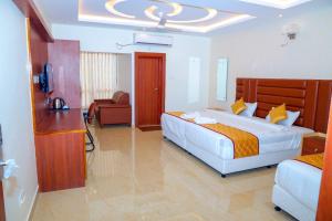una camera d'albergo con due letti e una televisione di Hotel Lorven a Tirupati