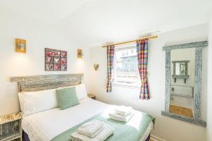 um pequeno quarto com uma cama e um espelho em Fern Lodge 2 with Hot Tub em Belladrum
