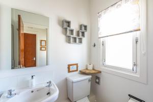 a bathroom with a sink and a toilet and a mirror at Fern Lodge 2 with Hot Tub in Belladrum +34 photos