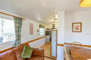 a living room with a couch and a table at Fern Lodge 2 with Hot Tub in Belladrum