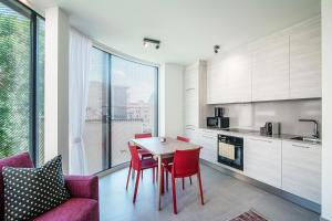 eine Küche und ein Esszimmer mit einem Tisch und Stühlen in der Unterkunft Flat Iron Apartments by Quokka 360 - modern building 5 min from the centre of Lugano in Viganello
