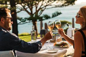 a man and woman sitting at a table with glasses of wine at Boutique Hotel Vivenda Miranda in Lagos