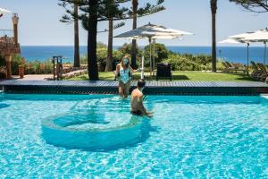 a man and woman standing in a swimming pool at Boutique Hotel Vivenda Miranda in Lagos