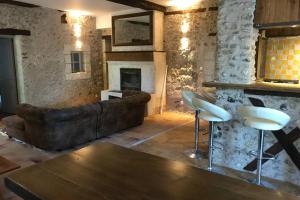 a living room with a couch and a fireplace at MAISON RESTAUREE 6 PERSONNES AU COEUR DU PERIGORD in Sourzac