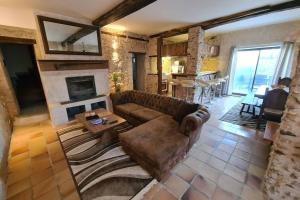 a living room with a couch and a fireplace at MAISON RESTAUREE 6 PERSONNES AU COEUR DU PERIGORD in Sourzac