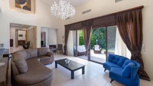 a living room with couches and a chandelier at Delta Wellness Villa in Ixia