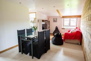Habitación con mesa de cristal y dormitorio. en Gîte Plume et Potiron, en Gisors