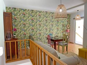a living room with a table and a wall mural at Thermal River Apartment in Furnas