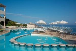 a swimming pool with a view of the ocean at Castelsardo Resort Village in Castelsardo