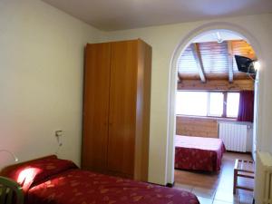 a bedroom with two beds and an arched doorway at Hotel La Rosa in Teglio