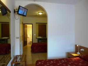 a living room with a couch and a tv on a wall at Hotel La Rosa in Teglio