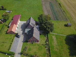 une vue aérienne sur une maison et un champ dans l'établissement Pension Nele Hohaus, à Neuharlingersiel