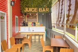 un restaurant avec des tables et des chaises et un bar à jus de fruits dans l'établissement Homestay Syariah Callista Bantaeng Mitra RedDoorz, à Bombong