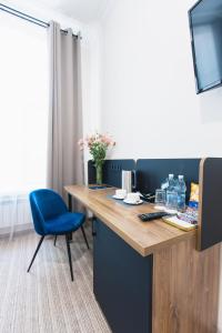 a desk with a blue chair in a room at Готель Континент Миколаїв in Mykolaiv