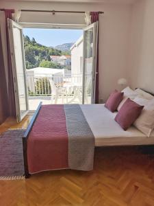 a large bed in a room with a large window at Apartments San Antonio in Korčula