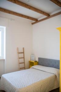 a bedroom with a white bed and a ladder at Agriturismo Antares in San Foca +70 photos