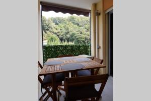 a wooden table with chairs and a large window at Appartement neuf près de la mer in Nice