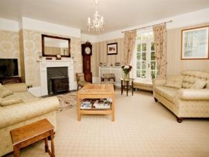 a living room with two couches and a fireplace at Smeaton Farm Luxury B&B in St. Mellion
