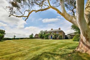 ein Baum vor einem Haus in der Unterkunft Smeaton Farm Luxury B&B in St Mellion