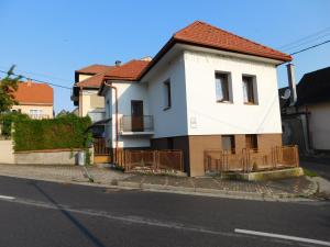 una casa blanca con techo rojo en una calle en Apartmán Magdaléna, en Závažná Poruba