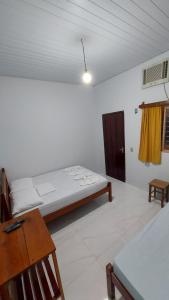 a bedroom with a bed and a desk and a table at POUSADA BEIRA RIO in Ponte Alta do Tocantins