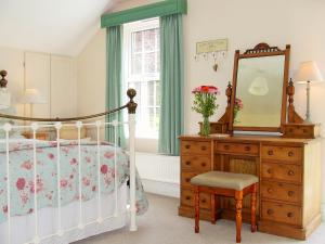オークハンプトンにあるLobhill Farmhouse Bed and Breakfast and Self Catering Accommodationのベッドルーム1室(ベッド1台、ドレッサー、鏡付)