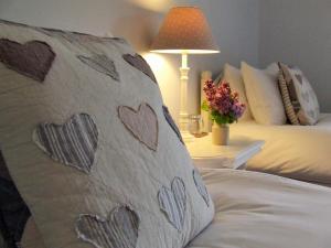 uma cama com uma almofada com corações em Lobhill Farmhouse Bed and Breakfast and Self Catering Accommodation em Okehampton