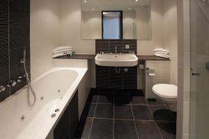 łazienka z wanną, umywalką i toaletą w obiekcie Van der Valk Hotel Rotterdam Ridderkerk w mieście Ridderkerk