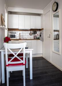 a kitchen with a white table and a red chair at Karl-Oskars Krypin in Visby