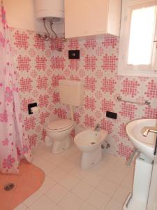 łazienka z toaletą i umywalką w obiekcie Comfort and beauty in our precious villa for 6 w mieście Porto Santa Margherita di Caorle