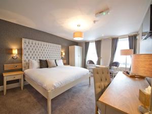 een slaapkamer met een groot wit bed in een kamer bij The County Hotel in Hexham