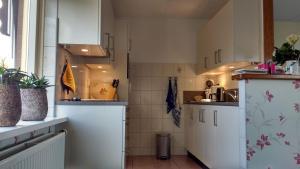 a small kitchen with white cabinets and a window at b&b de Vlinder in Hardenberg