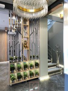 einen Kronleuchter in einer Lobby mit Topfpflanzen in der Unterkunft AREDO HOTEL in Rostow am Don