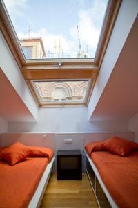 two beds in a room with a skylight at Apartamentos Turisticos Torico Amantes in Teruel