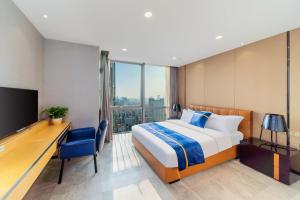 Habitación de hotel con cama, escritorio y TV. en Cloudy international apartment Beijing Rd A-mall en Guangzhou